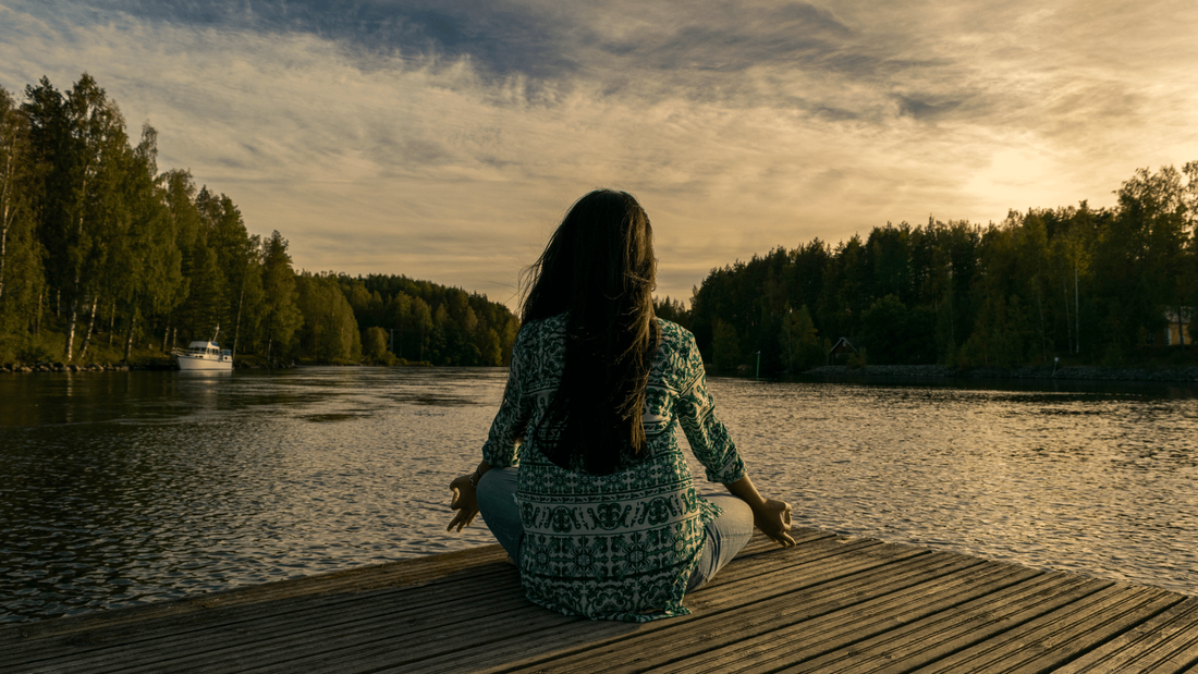 woman sitting on dock meditating
